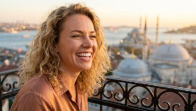 Een gelukkige vrouw met een perfect wit gebit glimlacht vol zelfvertrouwen, met de onscherpe skyline van Istanbul op de achtergrond tijdens een zonsondergang. Het beeld straalt gezondheid, geluk en reizen uit.