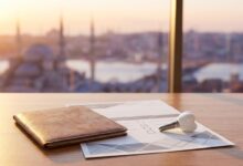 Conceptueel beeld over tandheelkundig toerisme en zorgverzekering, met een paspoort, een leeg formulier en een tandimplantaatmodel op een bureau, tegen een wazige achtergrond van de skyline van Istanbul.